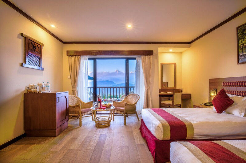 A deluxe room at Rupakot Resort with a window onto the mountains